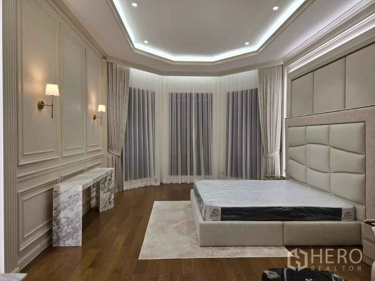 Detached House for rent or sale in Bang Kapi, Bangkok - Spacious master bedroom with bay windows, marble console and soft wall sconces.