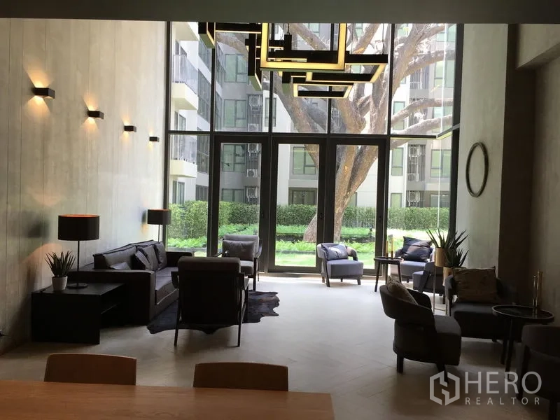 Condominium for sale in Phaya Thai, Bangkok - Double-height residents’ lounge with modern sofas and garden view.