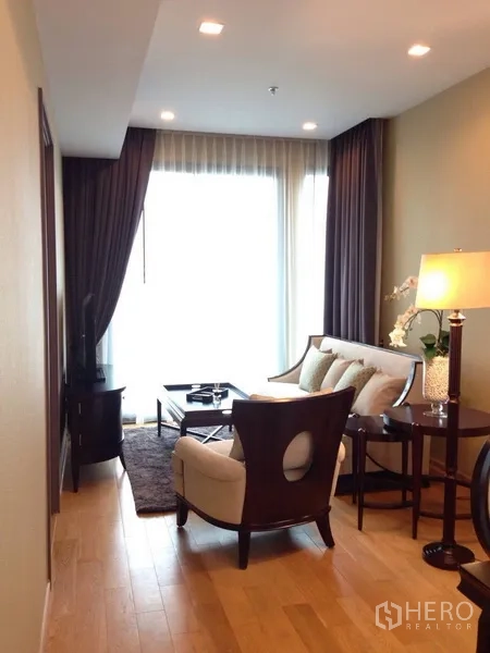Condominium for rent in Khlong Toei, Bangkok - Bright condo living room with floor-to-ceiling window, sofa set and coffee table.