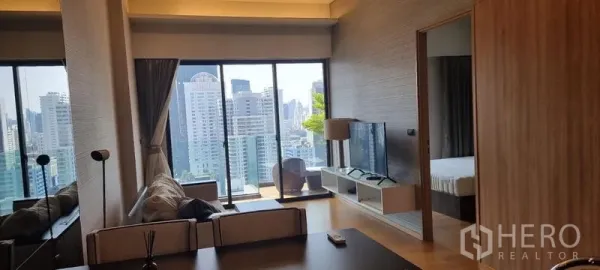 คอนโด ขายในWatthana, Bangkok - พื้นที่นั่งเล่นกว้าง หน้าต่างบานใหญ่ มีชั้นวางทีวี และทางเข้าห้องนอนกับระเบียง