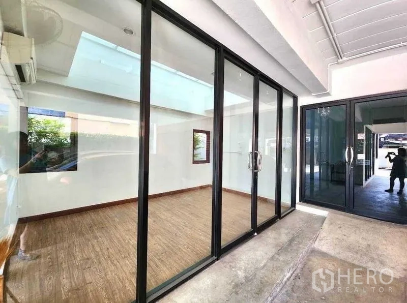 Office Space for rent or sale in Din Daeng, Bangkok - Glass-partitioned office room viewed from the corridor with sliding doors.