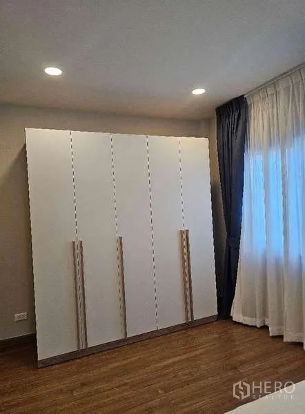 Detached House for rent in Bang Phli, Samut Prakan - Bright room featuring a large white wardrobe, recessed lighting and sheer curtains.