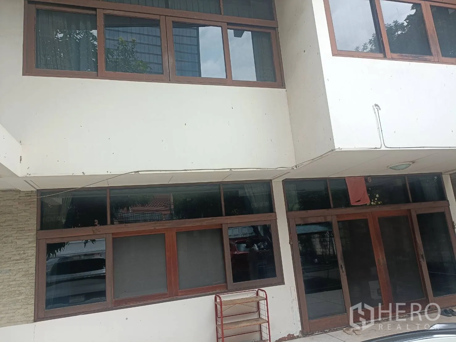独立式住宅 出租在Bang Rak, Bangkok - 一层入口，木框推拉门与宽大的窗户。