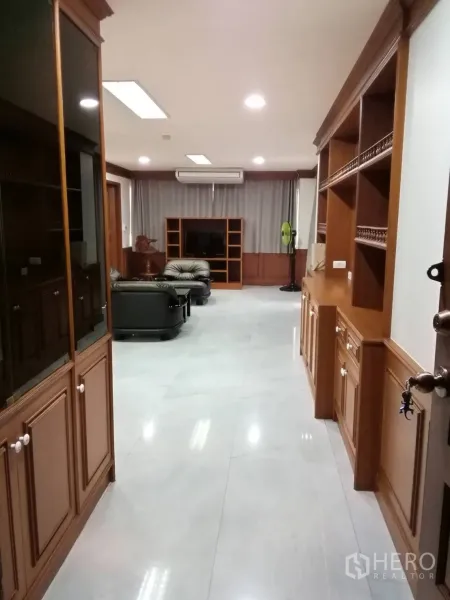 公寓 出租或出售在Watthana, Bangkok - 走廊通向宽敞客厅，沿墙设有大面积木质柜体。