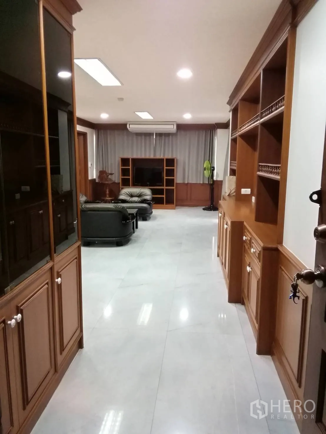 公寓 出租或出售在Watthana, Bangkok - 走廊通向宽敞客厅，沿墙设有大面积木质柜体。