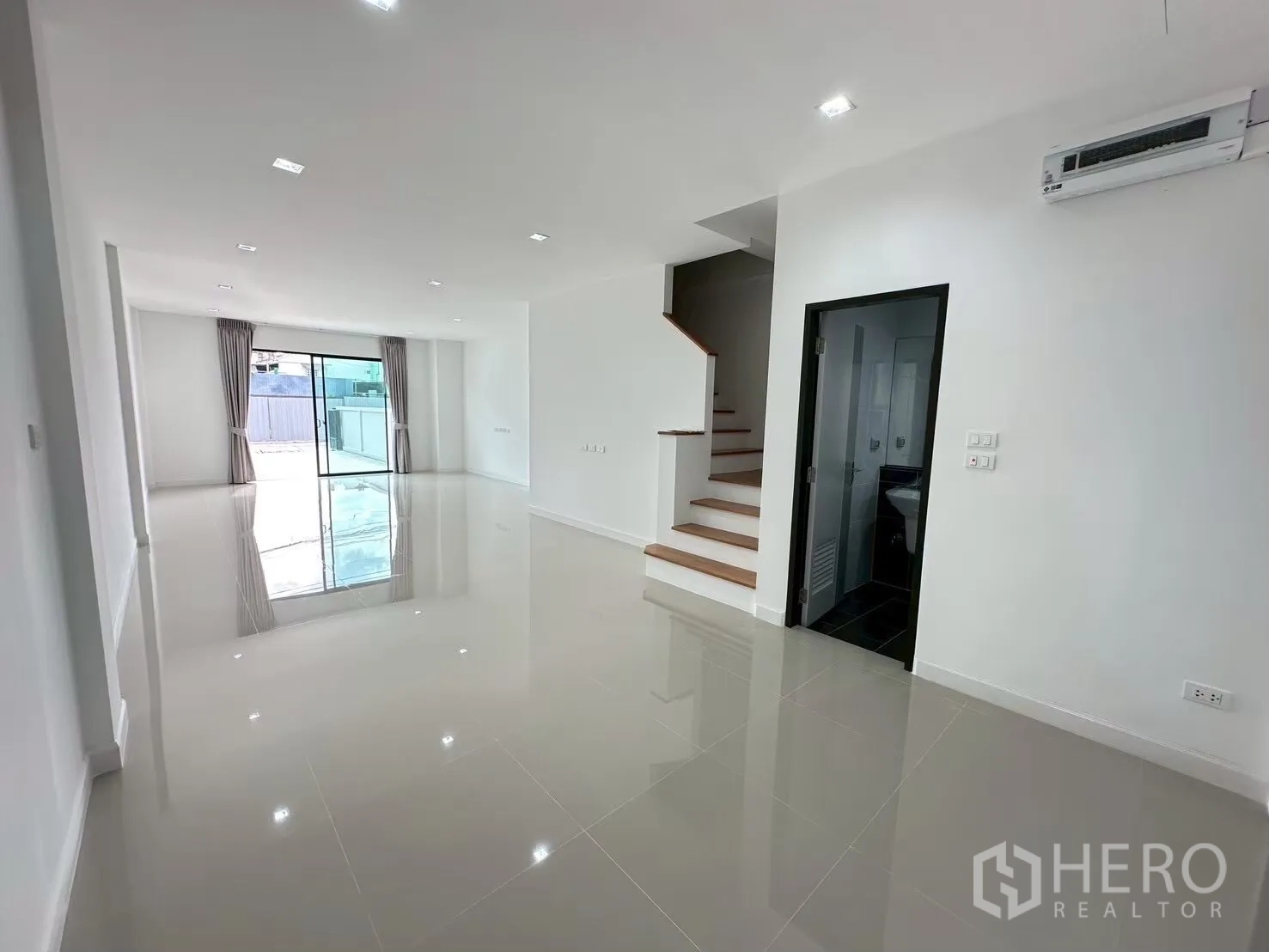 Home Office for rent in Lat Phrao, Bangkok - Open living or office area with sliding doors to the front terrace, stairs, and guest bath.