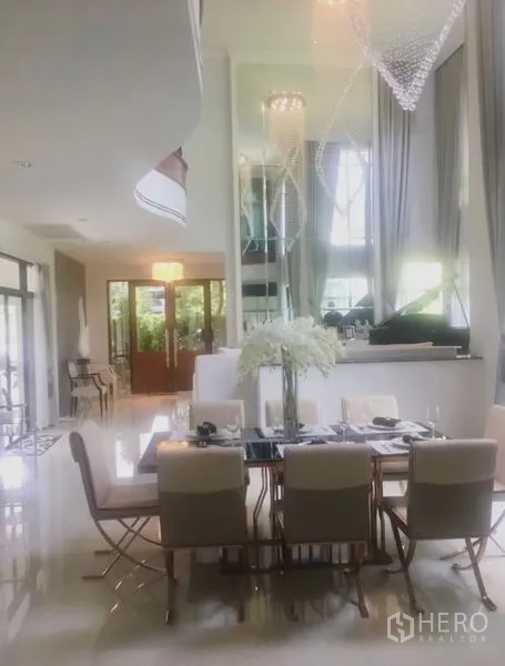 Detached House for sale in Saphan Sung, Bangkok - Dining room with high ceiling, large windows and crystal chandeliers opening to the garden.