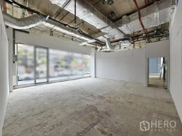 Retail Space for rent - Shell retail interior with high ceilings, exposed ducting, concrete floor and large front glazing.