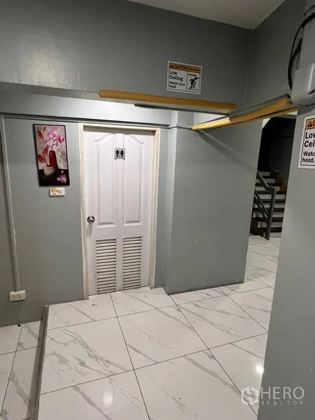 零售空间 出租在Khlong Toei, Bangkok - 室内走廊，低顶警示标识，连通服务门与楼梯。
