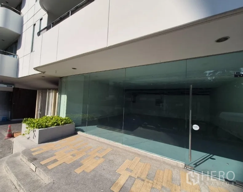 Retail Space for rent in Watthana, Bangkok - Wide shopfront with expansive glazing, planter box, and non-slip entrance paving at street level.
