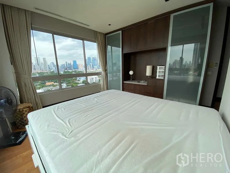 公寓 出租在Yan Nawa, Bangkok - 主臥室設整面窗與衣櫃，俯瞰城市景觀。