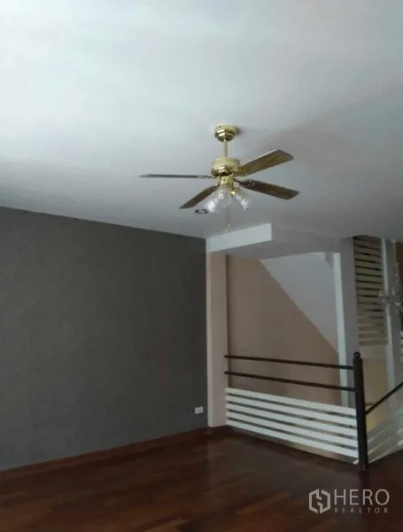 Home Office for rent in Bueng Kum, Bangkok - Upper-floor landing with ceiling fan, wooden flooring and stair railing.