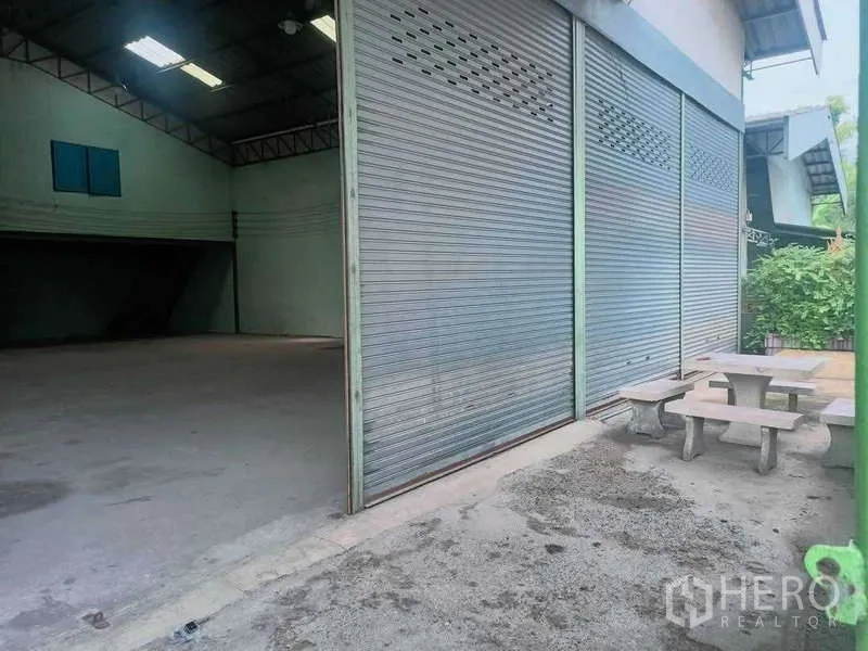 货栈 出售在Khlong Luang, Pathum Thani - 卷闸门打开，露出宽敞库区与户外石桌座位