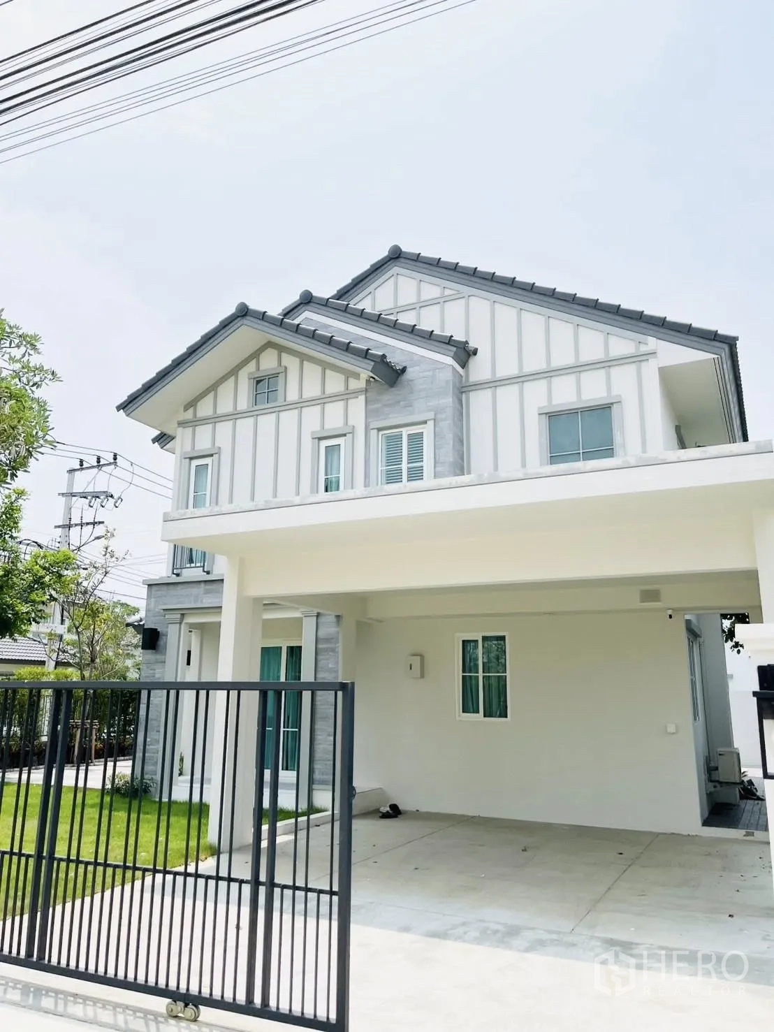 บ้านเดี่ยว for rent in Bang Phli, Samut Prakan - ด้านหน้าบ้านพร้อมทางเข้ารั้วและที่จอดรถมีหลังคาคลุม.