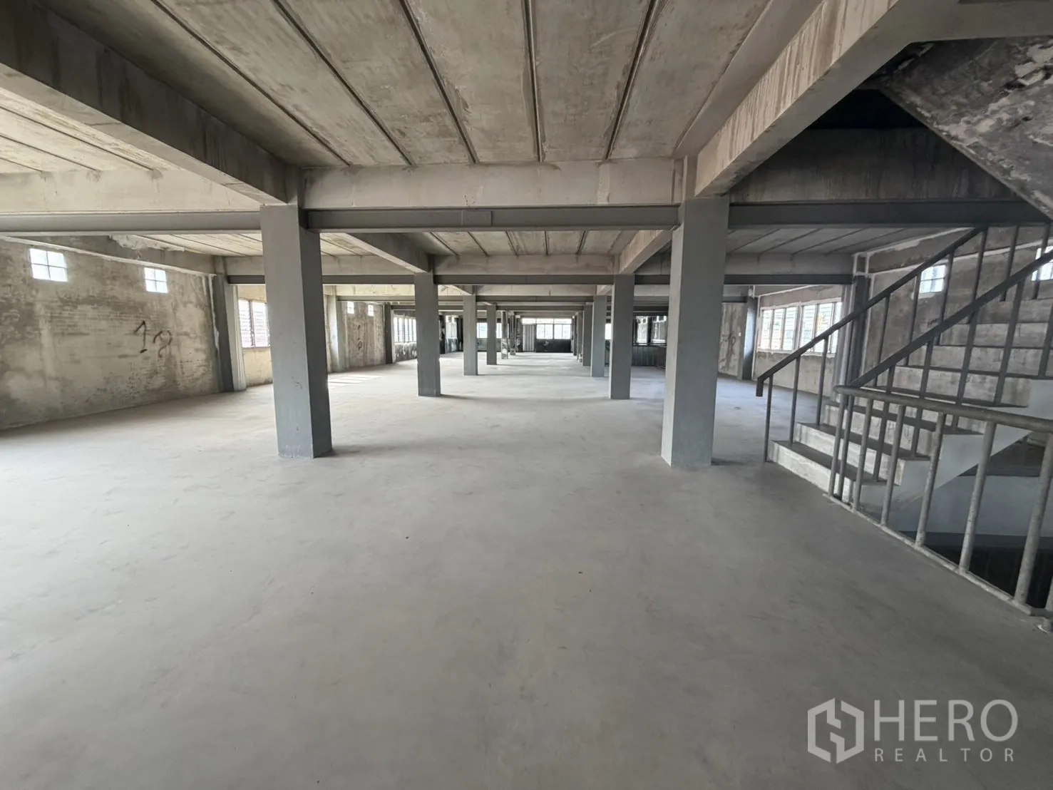 工厂 for rent or sale in Bang Bon, Bangkok - 开放式厂房楼层，混凝土立柱与室内楼梯。