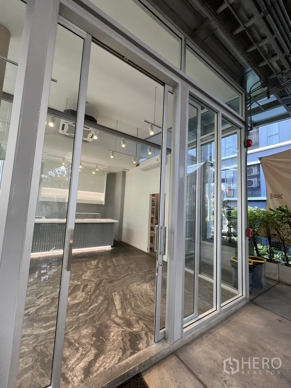 Retail Space for rent in Khlong Toei, Bangkok - Wide sliding glass storefront and covered walkway leading into a modern retail space.