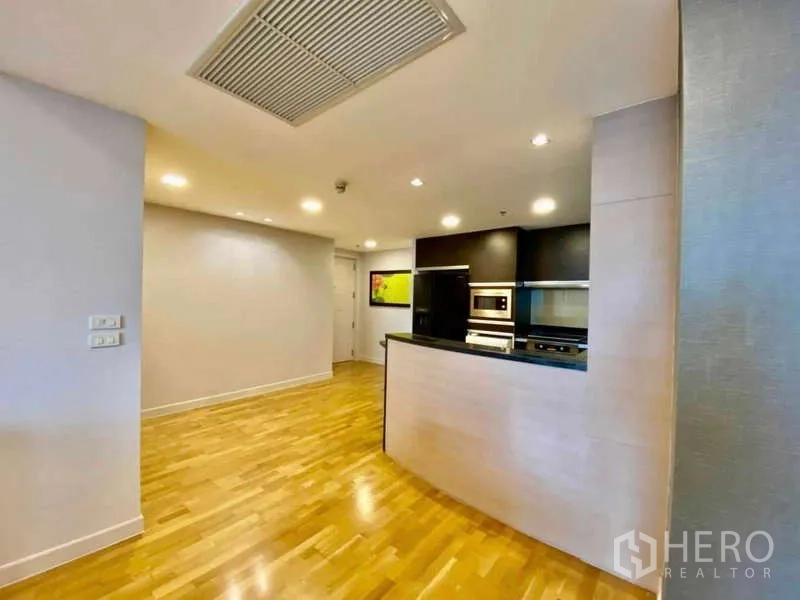 Condominium for rent or sale in Sathon, Bangkok - Open kitchen with breakfast bar and wooden flooring in the entry hall.