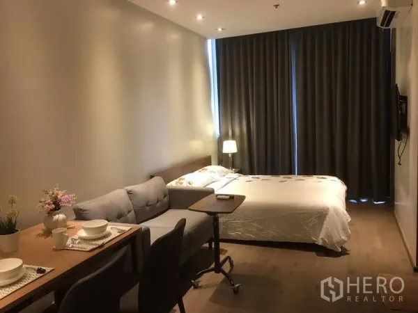 公寓 出租在Khlong Toei, Bangkok - 一体化起居空间，餐桌、沙发与床，木地板，大幅窗帘。