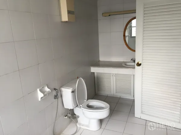 公寓 出租在Watthana, Bangkok - 白色瓷砖浴室，带坐便器与圆镜洗手台