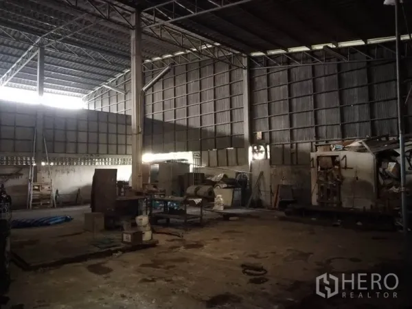 Warehouse for rent in Saphan Sung, Bangkok - Spacious high‑ceiling warehouse interior with steel trusses, corrugated metal walls, and open floor space for storage or light production.