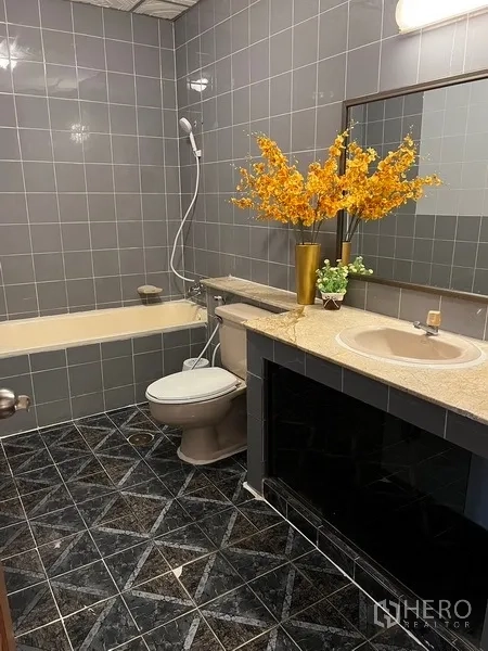 Home Office for rent in Suan Luang, Bangkok - Bathroom with bathtub, gray tiles, vanity and mirror.