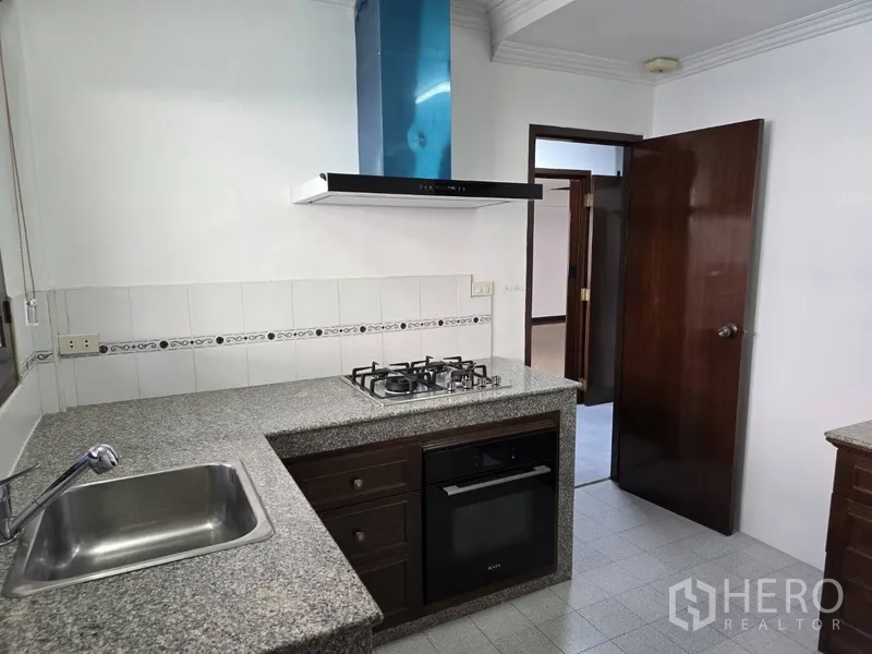 独立式住宅 出租在Watthana, Bangkok - 西式厨房配花岗岩台面、燃气灶、烤箱与抽油烟机。
