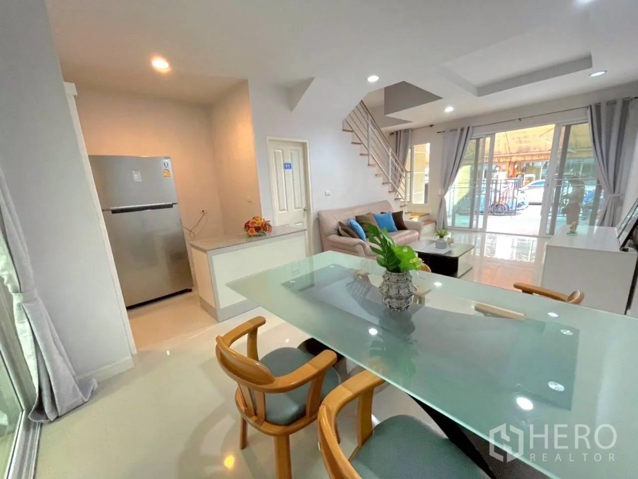 Townhouse for rent in Bang Kho Laem, Bangkok - Open dining and living space with glass doors to the front patio and staircase.