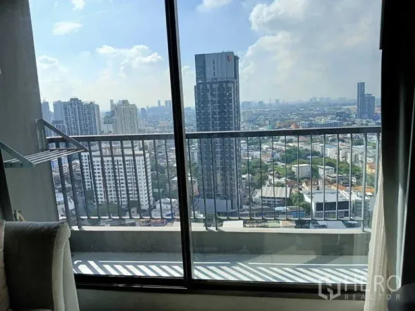 Condominium for rent - High-floor balcony view through glass door showing Phra Khanong and Sukhumvit skyline.