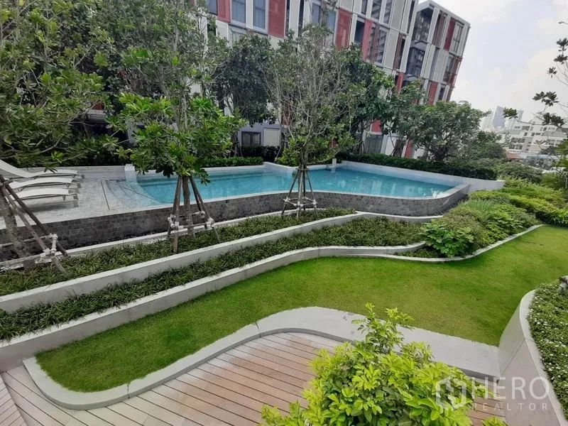 公寓 出租或出售在Watthana, Bangkok - 多层次景观花园与木步道，通往抬高的泳池与躺椅区。