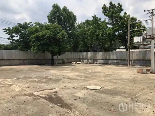 คลังสินค้า ให้เช่าในLak Si, Bangkok - ลานคอนกรีตขนาดใหญ่ล้อมรั้ว มีต้นไม้และเสาไฟ เหมาะสำหรับจอดและกลับรถบรรทุก