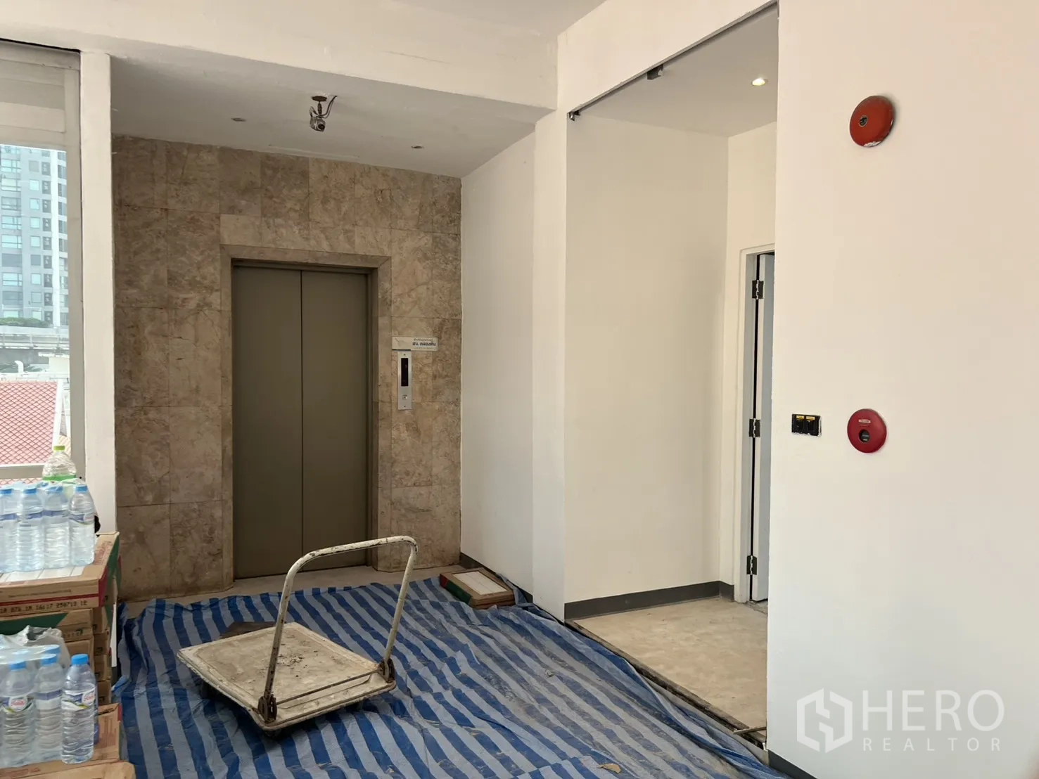 办公空间 出租在Watthana, Bangkok - 电梯前厅，石材包覆的电梯入口与消防设施。