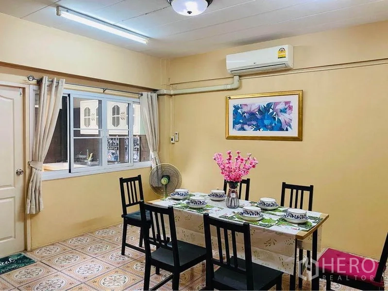 联排别墅 出租或出售在Prawet, Bangkok - 餐厅摆放六人餐桌，窗外连通厨房，配备空调。
