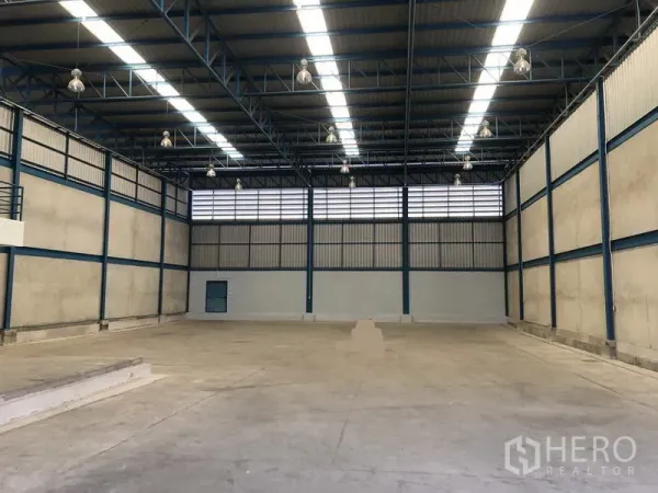 Warehouse for rent in Bang Phli, Samut Prakan - Spacious warehouse interior with high steel truss ceiling, skylights and polished concrete floor.