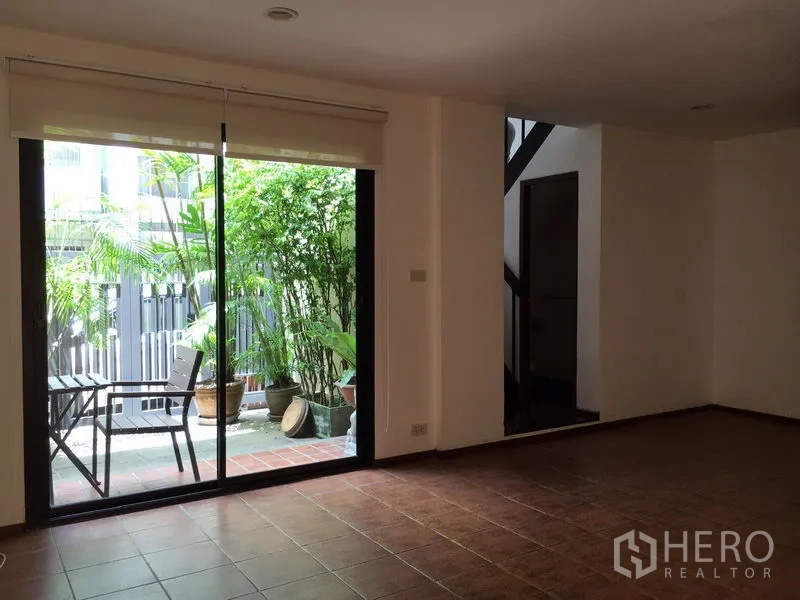 ทาวน์เฮาส์ ให้เช่าในWatthana, Bangkok - ห้องนั่งเล่นสว่างด้วยประตูกระจกบานเลื่อน เปิดสู่สวนระเบียงเล็ก