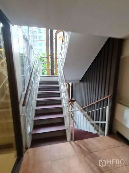 店屋 出售在Watthana, Bangkok - 室内楼梯间，金属扶手与自然采光。