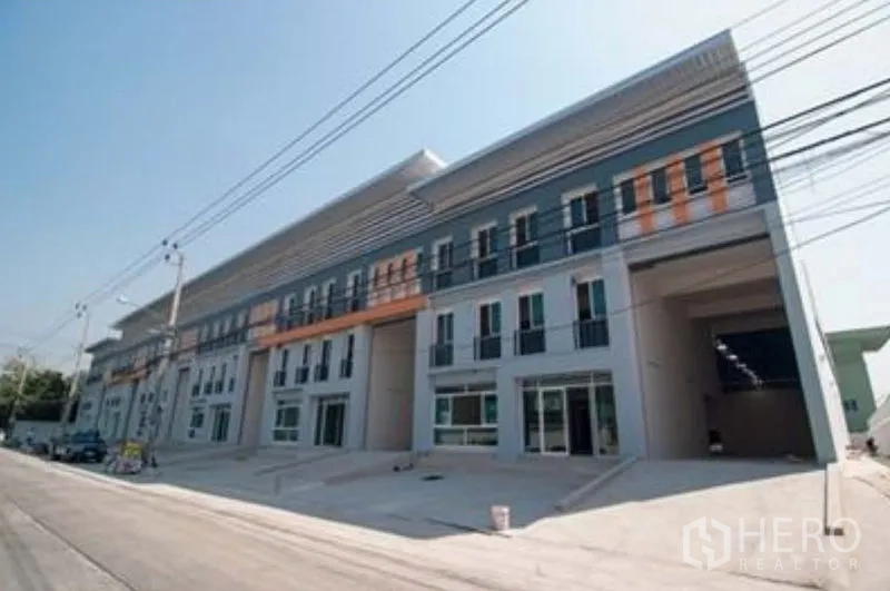 Factory for rent in Bang Sao Thong, Samut Prakan - Street view of new industrial block with multiple units and ramps.