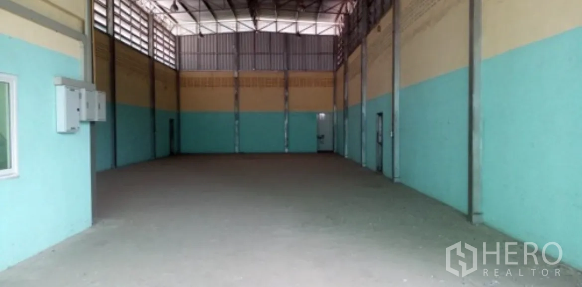 Warehouse for rent in Pak Kret, Nonthaburi - Wide view of the warehouse interior with tall roof and lighting.