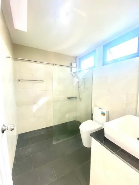 Townhouse for rent in Prawet, Bangkok - Modern bathroom with glass-enclosed shower, light wall tiles and toilet.