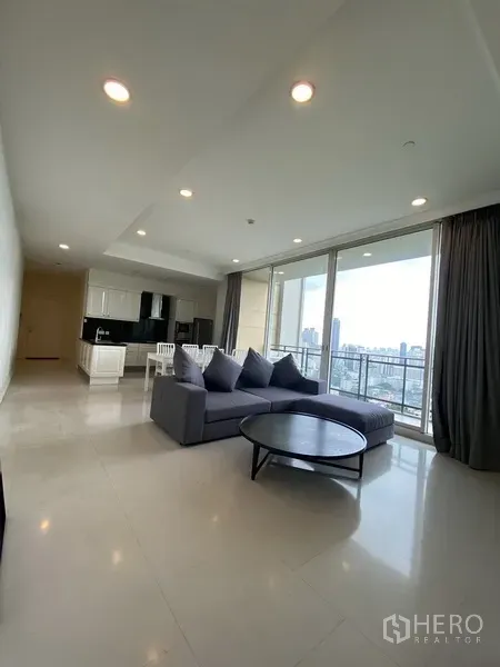 公寓 出租在Watthana, Bangkok - 明亮客厅，落地窗连接阳台，俯瞰曼谷天际线的两卧公寓。