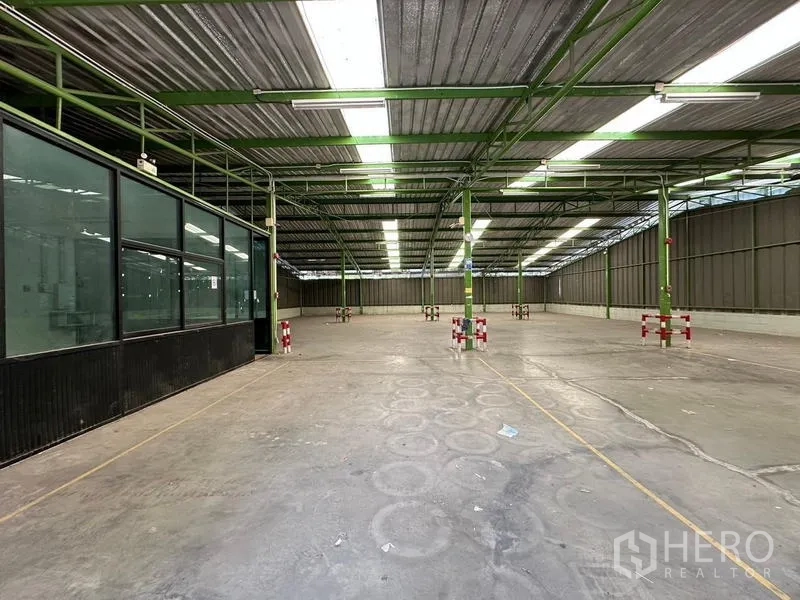 Warehouse for rent in Prawet, Bangkok - Open storage space with marked bays and roof lighting.