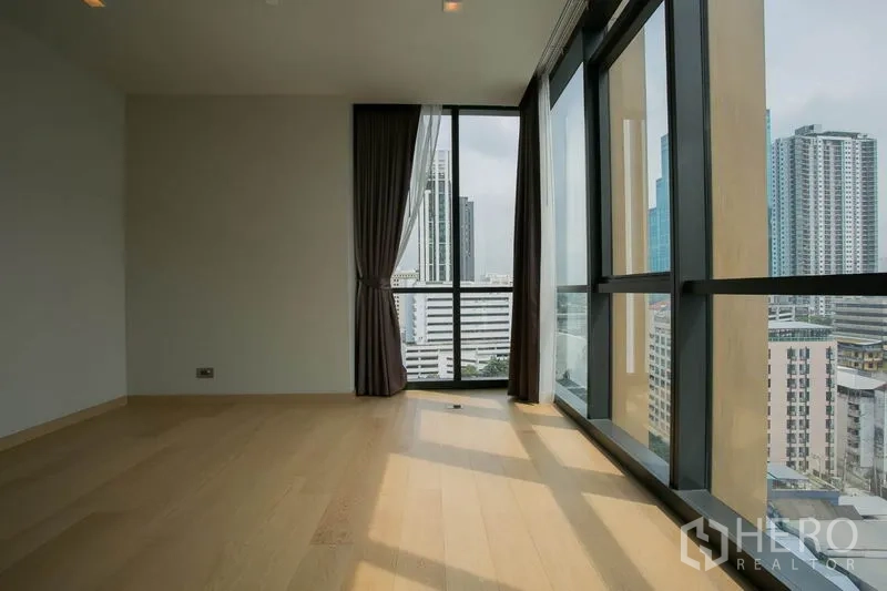 公寓 出租或出售在Watthana, Bangkok - 明亮转角房，落地窗与浅色木地板，享城市全景。