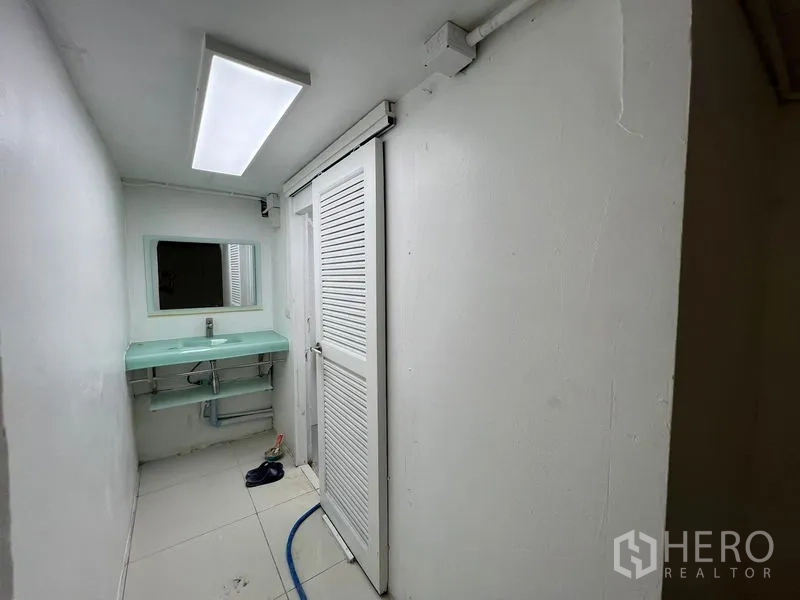 Retail Space for rent in Khlong Toei, Bangkok - Compact restroom area with sliding door and mint glass sink.