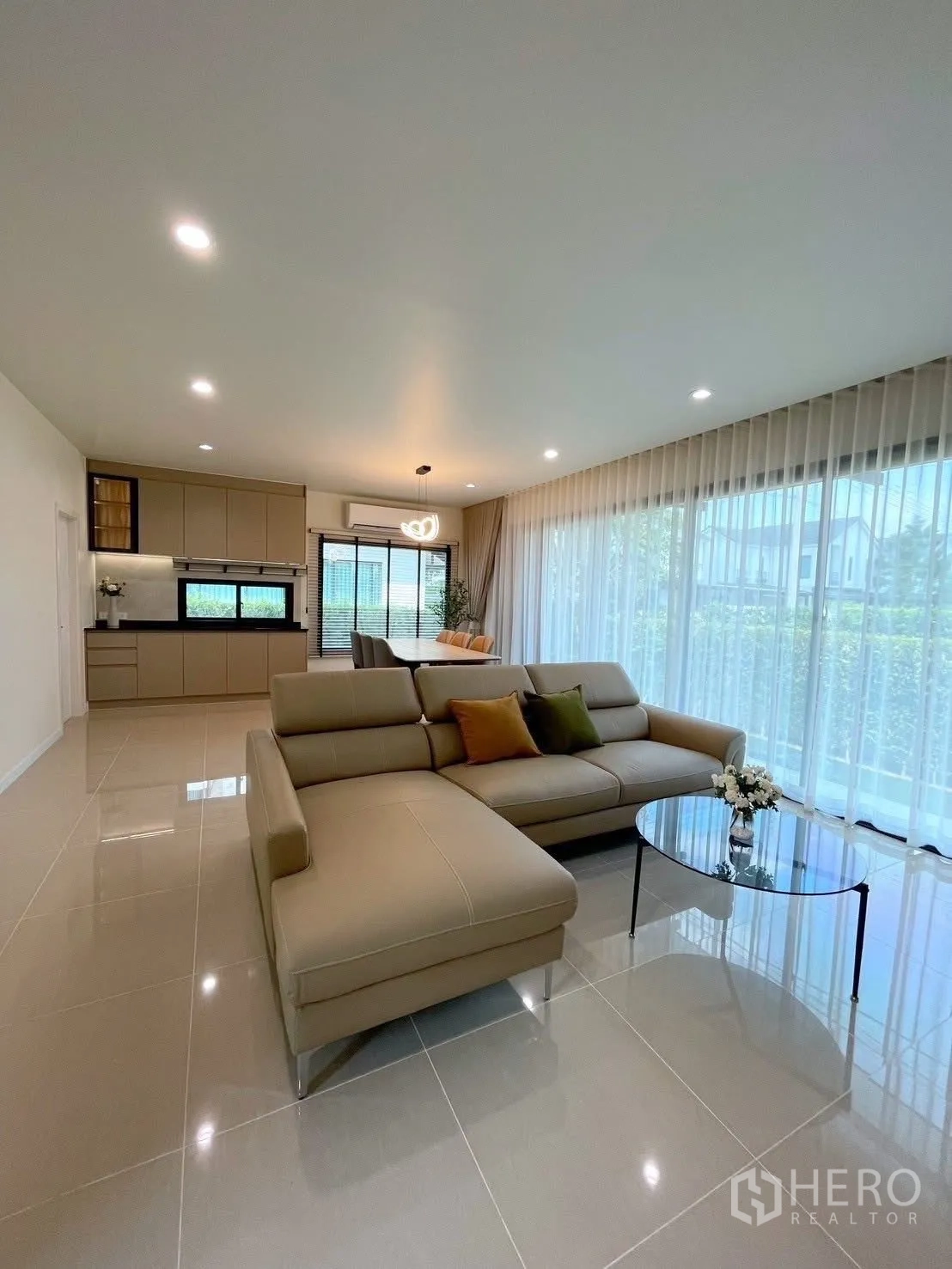 บ้านเดี่ยว for rent in Bang Phli, Samut Prakan - โซนรับแขกแบบโอเพ่นแพลนพร้อมโซฟาตัวยาว โต๊ะกลางกระจก และวิวสวน