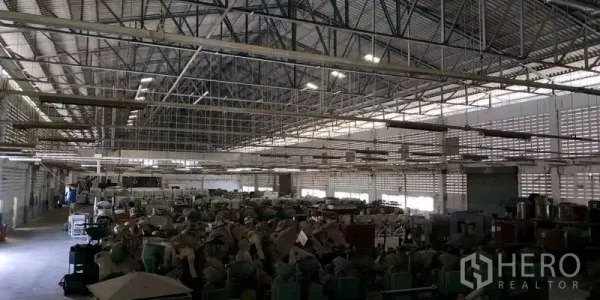 工厂 出租在Chachoengsao - 宽敞仓库内部，高钢架屋顶与采光窗，上存放设备