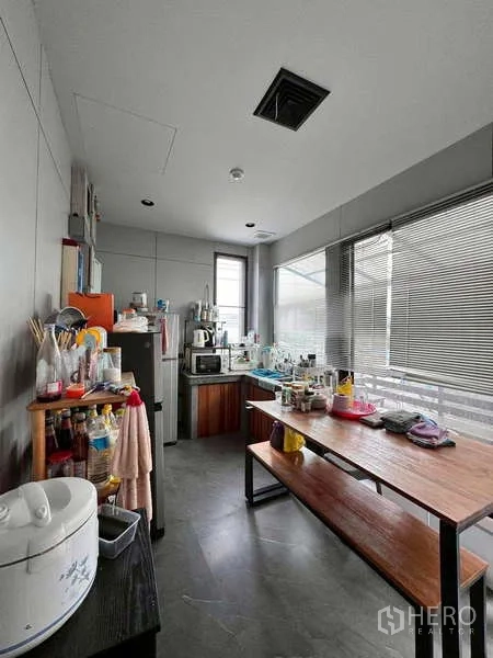 Warehouse for rent in Prawet, Bangkok - Staff pantry with sink, shelving, appliances, and dining bench.