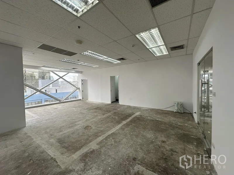 Office Space for rent in Watthana, Bangkok - Open office area with a doorway to an internal room and wide windows.