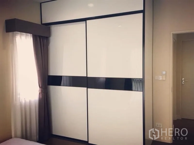 Detached House for sale - Bedroom with built-in white sliding wardrobe and a small window.
