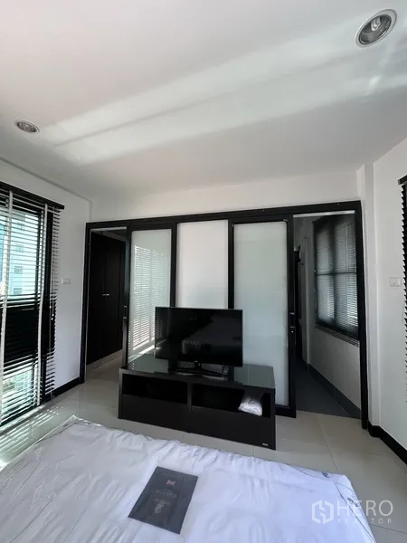 公寓 出租在Khlong Toei, Bangkok - 卧室视角，电视柜与推拉玻璃门通向衣帽间或套卫。