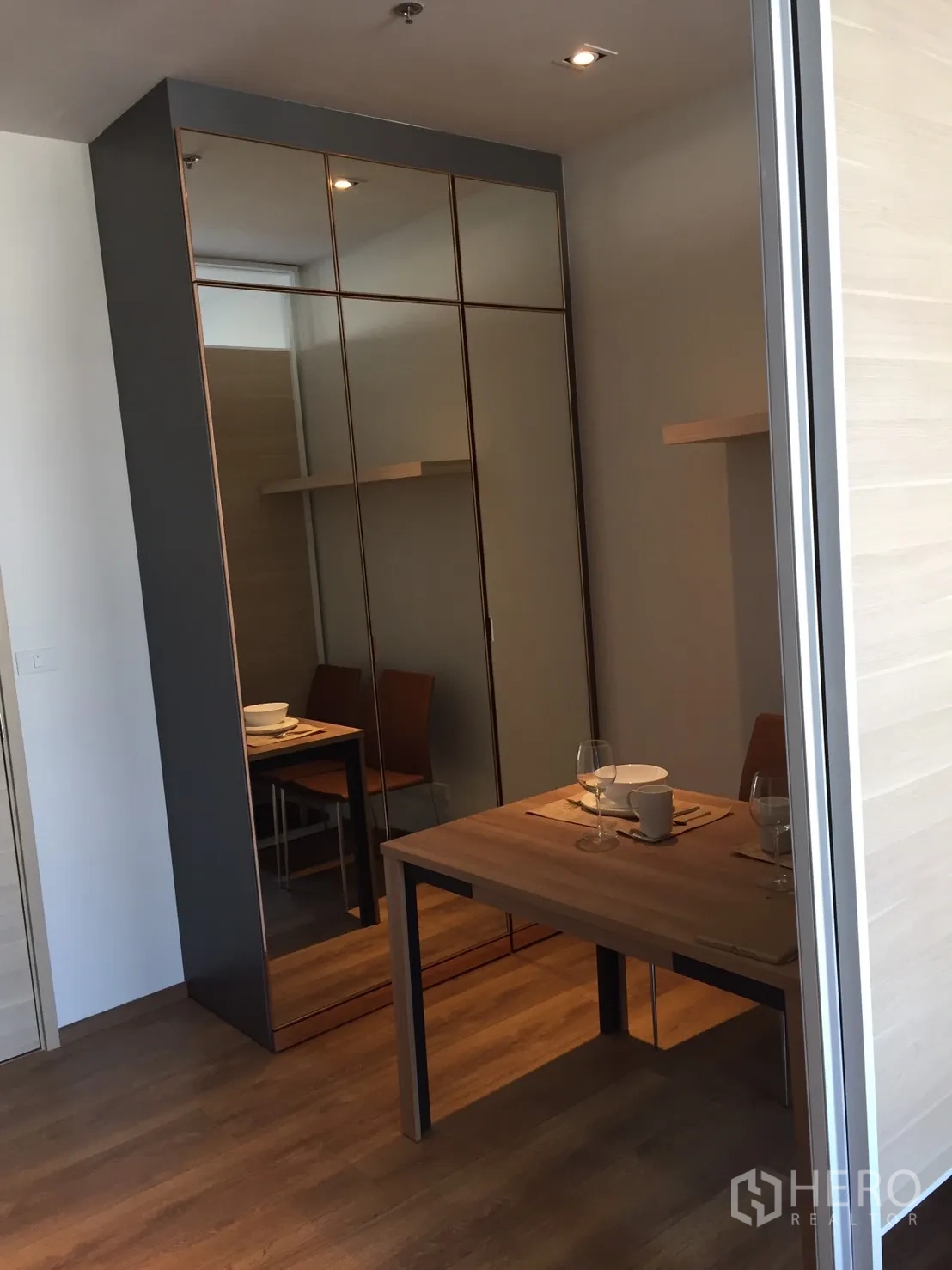 公寓 出租或出售在Khlong Toei, Bangkok - 现代公寓内的镜面衣柜与小型餐桌