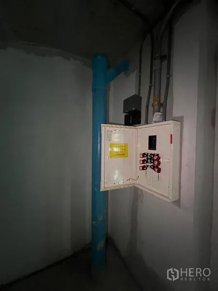 Retail Space for rent in Pathum Wan, Bangkok - Electrical panel and blue plumbing riser inside a service corner.
